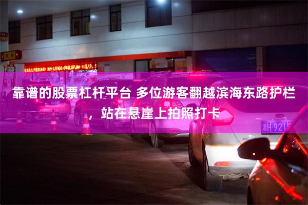 靠谱的股票杠杆平台 多位游客翻越滨海东路护栏，站在悬崖上拍照打卡